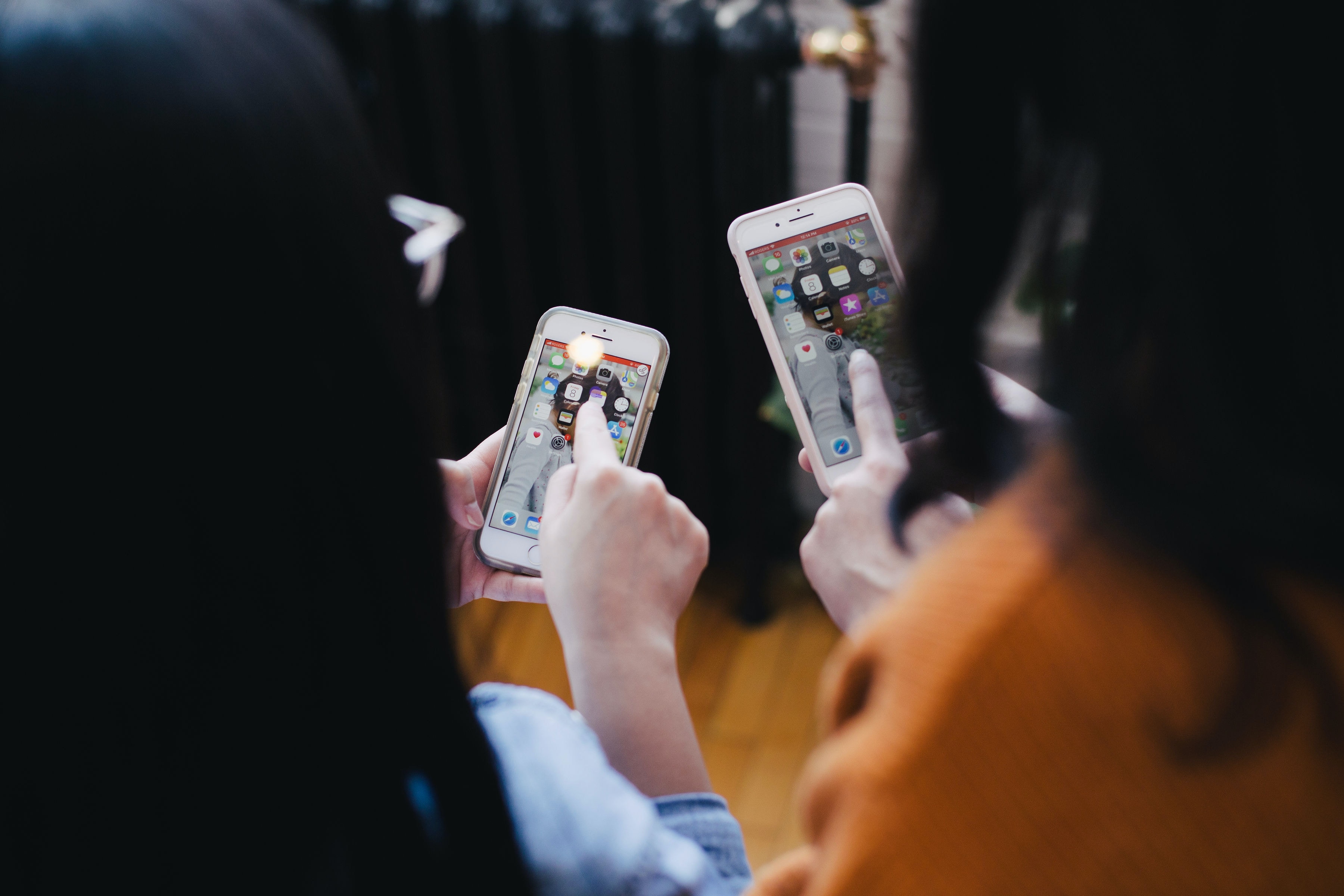 Ilustrasi dua orang perempuan sedang memegang gawai (Sumber gambar: Jason Goodman/Unsplash)