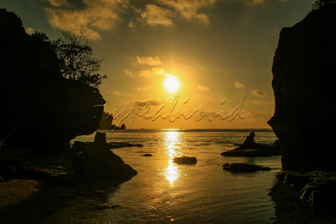 Suasana matahari tenggelam di Pantai Padang Padang, Bali. Pantai padang padang Bali yang masih alami ini beralamat di Desa Pecatu, Kecamatan Kuta Selatan, Kabupaten Badung. Banyak aktivitas yang bisa dilakukan pengunjung di pantai ini, apalagi banyak spot wisata paling menarik yang instagramable dan bila menjelang sore suasana romantisme akan begitu terasa di pantai ini karena wisatan dapat menikmati sunset yang indah.