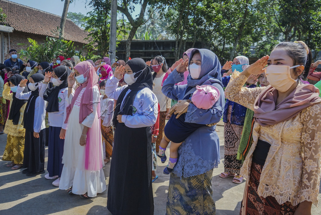Warga Desa Bendo Kecamatan Jabung kabupaten Malang melakukan Upacara dengan keterbatasan, Tua, Muda, anak-anak hingga Ibu-ibu yang menggendong bayinya turut berpartisipasi dalam Upacara Agustus 202idijalan desa dengan emamakai baju sehari-hari
