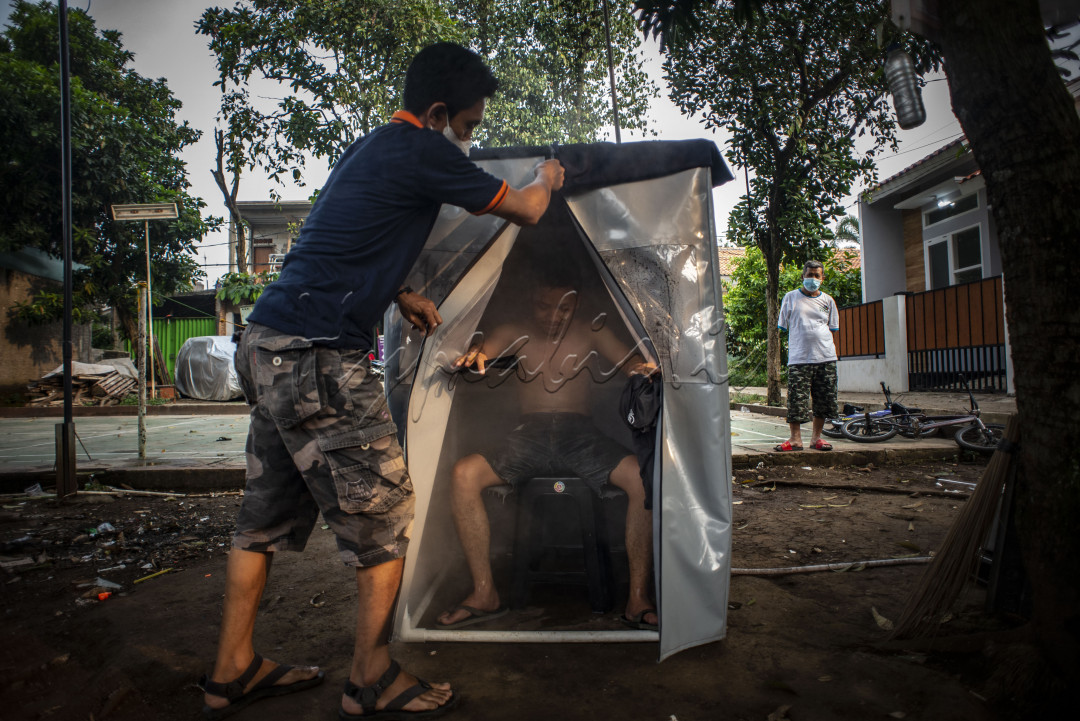 Warga berada di dalam bilik sauna dengan metode uap dari rempah-rempah di kawasan Gang Pepaya RT 11 RW 3, Lenteng Agung, Jagakarsa, Jakarta, Senin (19/7/2021). Menurut warga setempat, sauna tersebut sebagai salah satu bentuk untuk meningkatan imunitas tubuh di tengah pandemi COVID-19