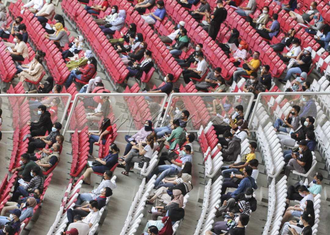 Jakarta, Indonesia, Sabtu 3 Juli : Ribuan warga menunggu untuk dilakukan penyuntikan vaksin Covid-19 di Gelora Bung Karno, Jakarta, Indonesia pada Sabtu 3 Juli 2021. Vaksinasi dilakukan secara massal dan gratis bagi warga ber-KTP DKI Jakarta ini, ditargetkan dapat dilakukan kepada sekitar 8.000 hingga 10.000 peserta per hari nya guna sebagai upaya percepatan memutus penyebaran virus Corona di Jakarta. 