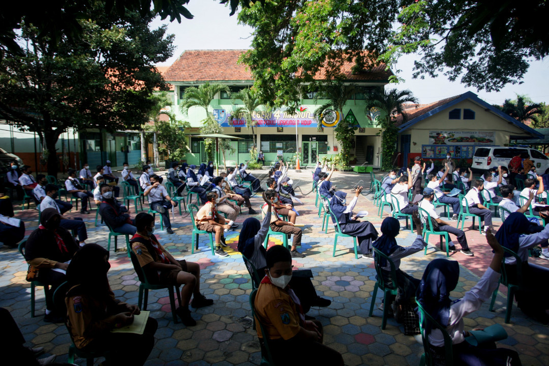 Sejumlah pelajar bersiap mengikuti kegiatan vaksinasi massal untuk pelajar di SMPN 4 Madiun, Jawa Timur, Kamis (19/8/2021). Presiden Joko Widodo menargetkan hingga akhir Agustus 2021 jumlah penerima vaksin COVID-19 di Indonesia mencapai 100 juta guna membentuk kekebalan kelompok sehingga pandemi COVID-19 segera berakhir. Foto: Muhamad Solihin
