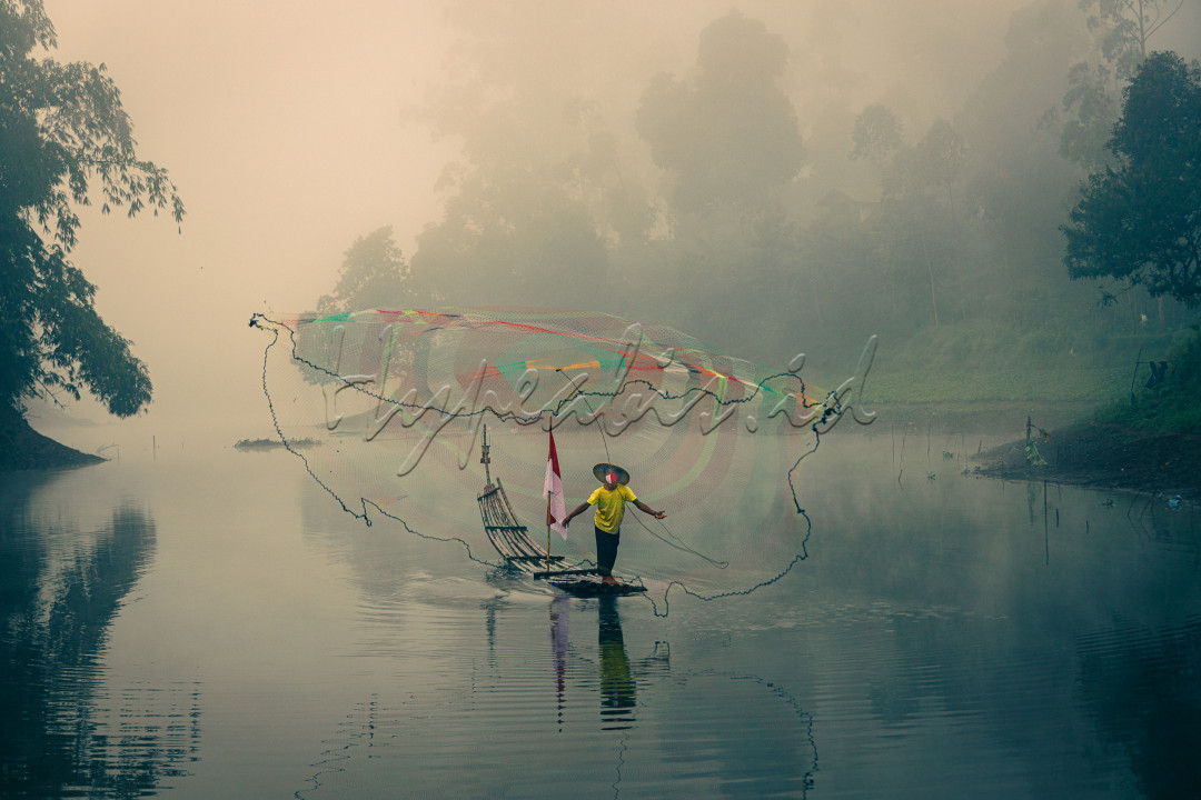 Seorang penjala ikan di daerah jawa barat yang bangga akan indonesia mengenakan masker merah putih. 