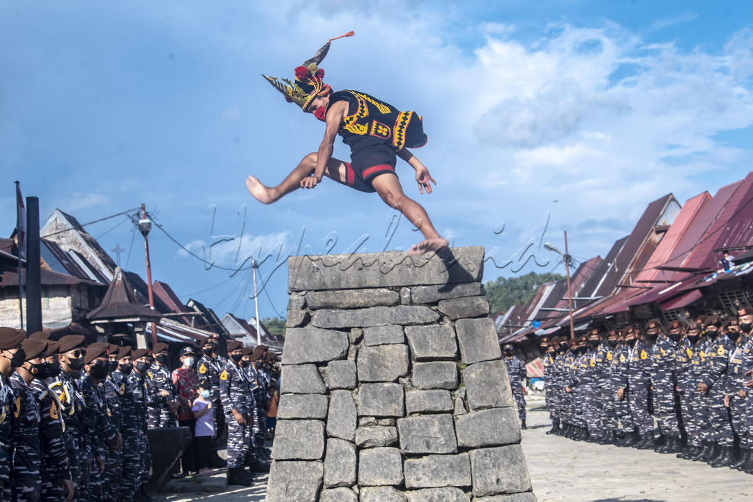 Seorang pemuda melompati hombo batu di Desa Wisata Bawomataluo, Nias Selatan, Sumatera Utara, Kamis (14/10/2021). Melompati batu tersebut merupakan tradisi bagi masyarakat desa adat Bawomataluo bagi para pemuda untuk menunjukan bahwa para pemuda laki-laki sudah dewasa dan siap untuk berperang. 