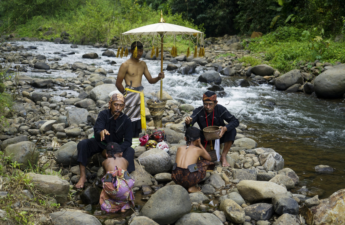 Tokoh adat Sunda Kabupaten Sumedang dan sesepuh Dusun Sanding menaburkan bunga saat prosesi "Ngaruwat Wahangan" di Leuwi Seeng, aliran Sungai Cicapar Desa Kaduwulung Kecamatan Situraja, Kabupaten Sumedang. Ngaruwat Wahangan ini merupakan salah satu prosesi meminta ijin pada pemilik semesta alam dan wujud syukur atas apa yang telah diberikan pada manusia terutama warga yang hidup di aliran sungai. Prosesi ini dilakukan oleh warga Dusun Sanding sebagai ungkapan syukur atas berkah semesta alam berupa aliran sungai yang mengaliri lahan dan sawah milik warga serta menjadikan objek wisata yang mampu bernilai ekonomi bagi warga sekitar.<br />
<br />
Prosesi Ngaruwat Wahangan dipimpin oleh seorang tokoh adat yang membuka prosesi dengan rajah dan kidung puji-pujian bagi leluhur mereka. Tokoh adat tersebut akan memercikkan air dan menaburkan bunga di kepala warga sebagai simbol kebersihan dan keindahan selalu mengiringi hidup para penerus generasi di kampungnya. Selanjutnya warga akan membawa air sungai ke dalam kendi yang terbuat dari tanah untuk dibagikan pada warga lainnya sebagai tanda keberkahan terus menerus yang dapat dinikmati oleh seluruh warga di Dusun Sanding.
