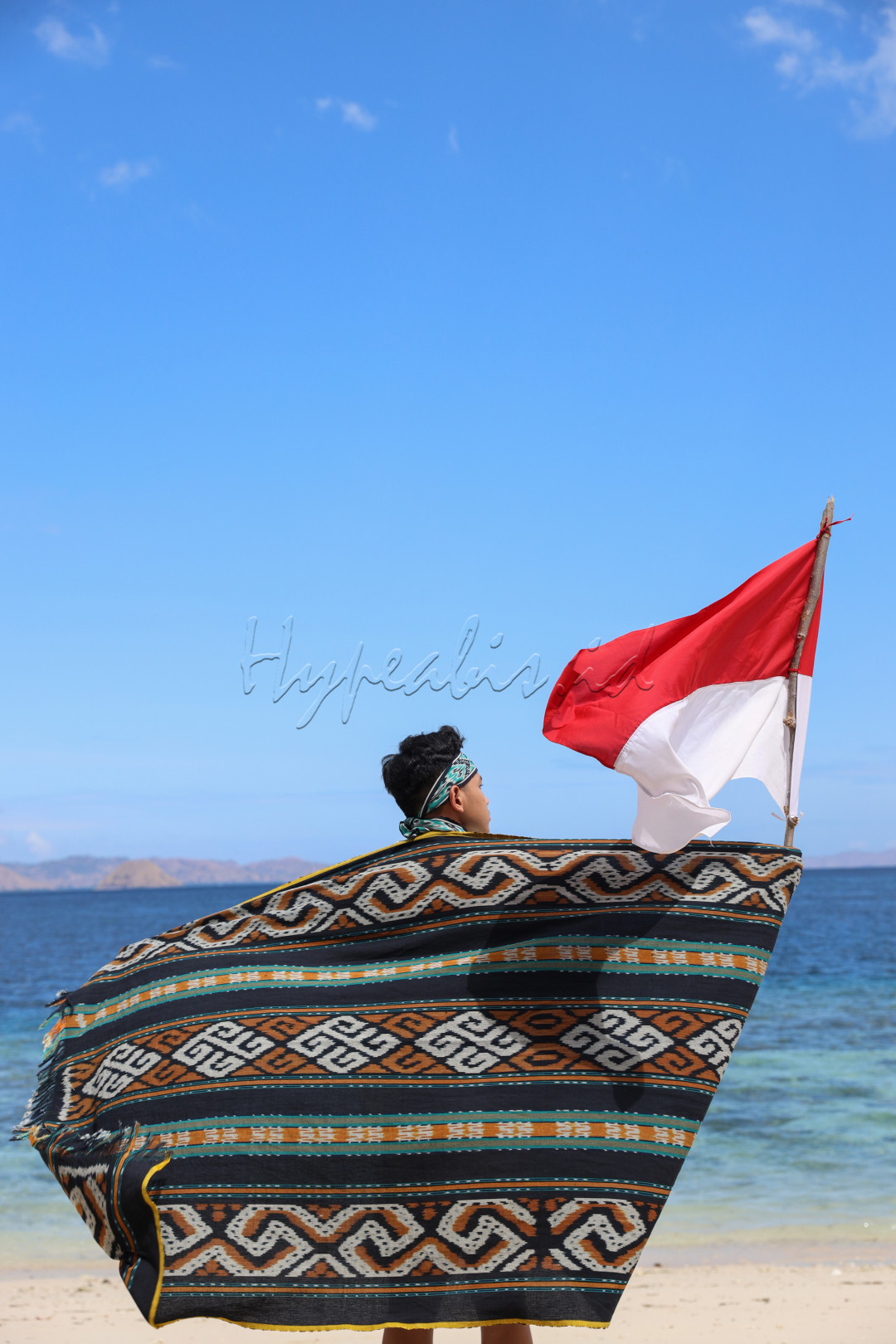 Pemuda Indonesia yang dengan bangga memakai kain tradisional dari Labuan Bajo, Kain Songke