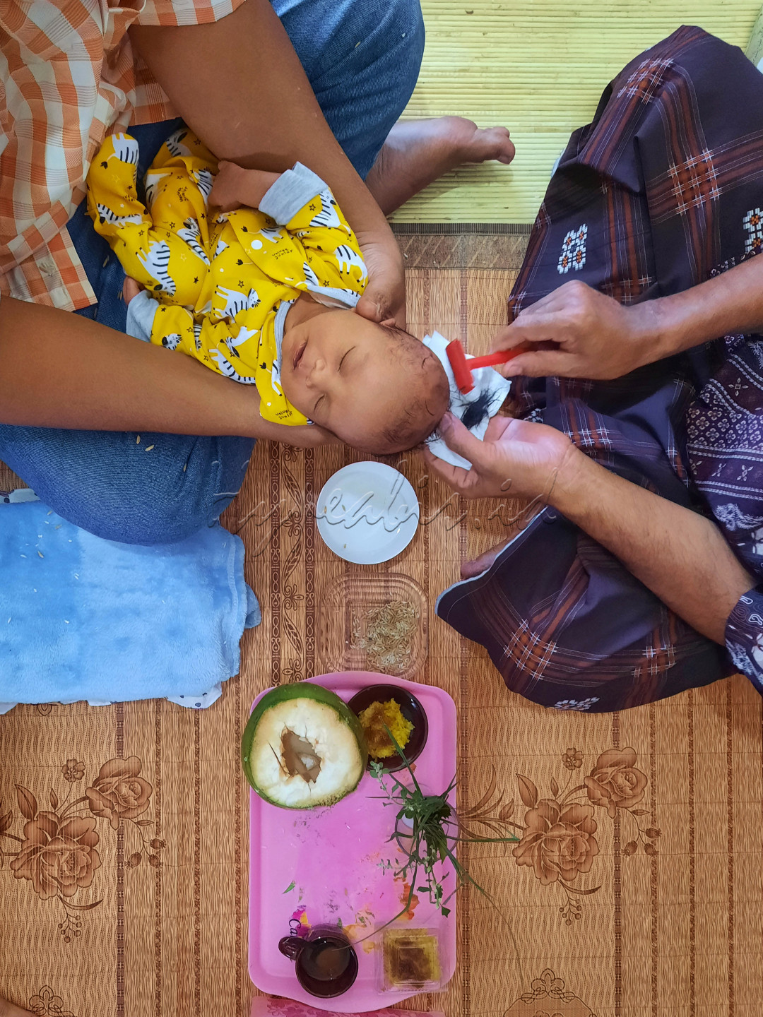 Seorang anak dilakukan pencukuran rambut dan pemberian beberapa jenis makanan sebagai sebuah acara aqiqah atau turun tanah di Aceh. Foto diambil pada 17 September 2021.