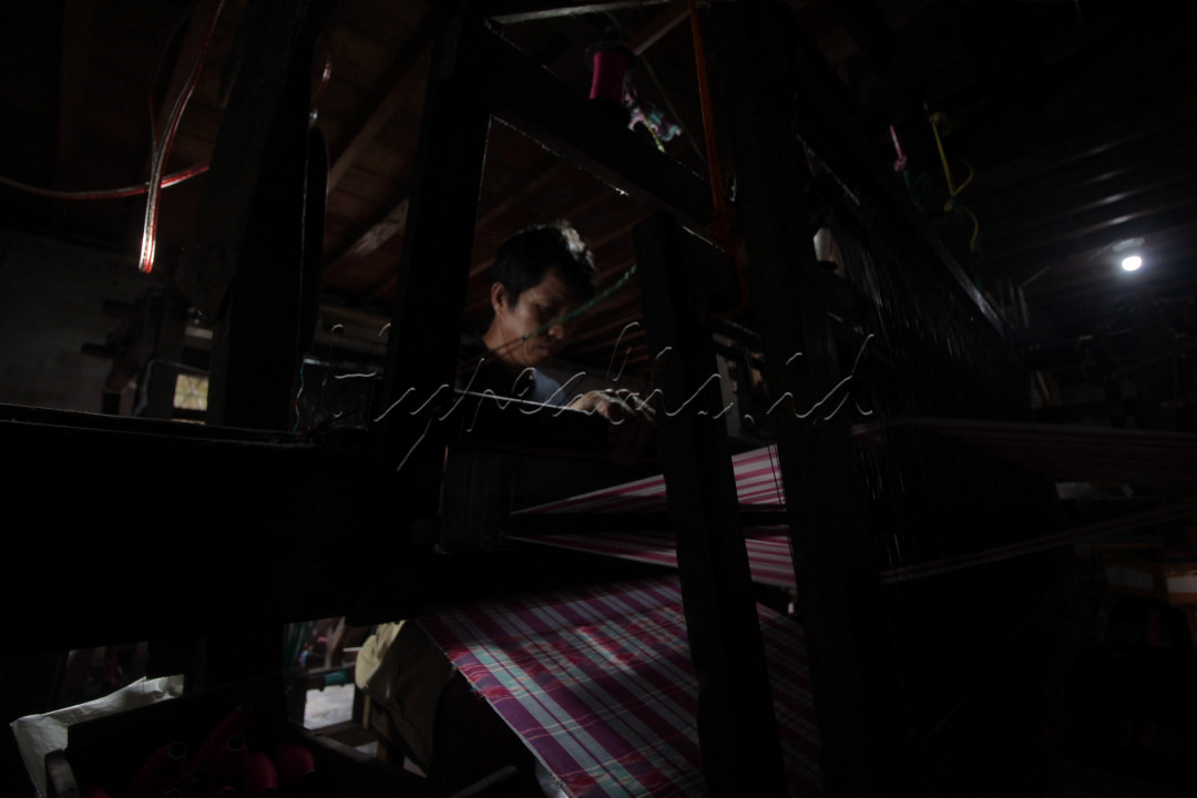 Judul : Alat Tradisional<br />
Pengrajin menenun kain tajung khas Palembang produksi rumahan dengan menggunakan alat tradisonal di kediamannya, kawasan Tuan Kentang, 15 Ulu, Kota Palembang, rabu, 20 artiOktober 2021. 