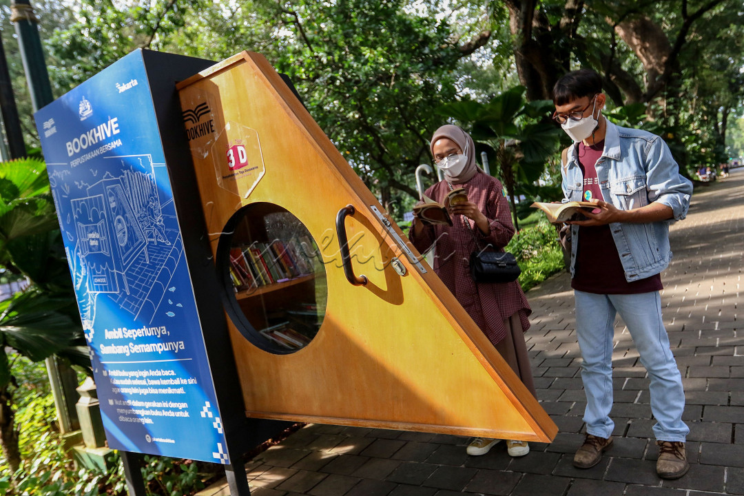  Pengunjung membaca buku di perpustakaan mini Taman Suropati, Jakarta. Membaca buku di ruang terbuka disebut memiliki banyak manfaat, membaca di bawah cahaya terang membuat area otak bisa memproses informasi visual secara lebih efektif. <br />
<br />

