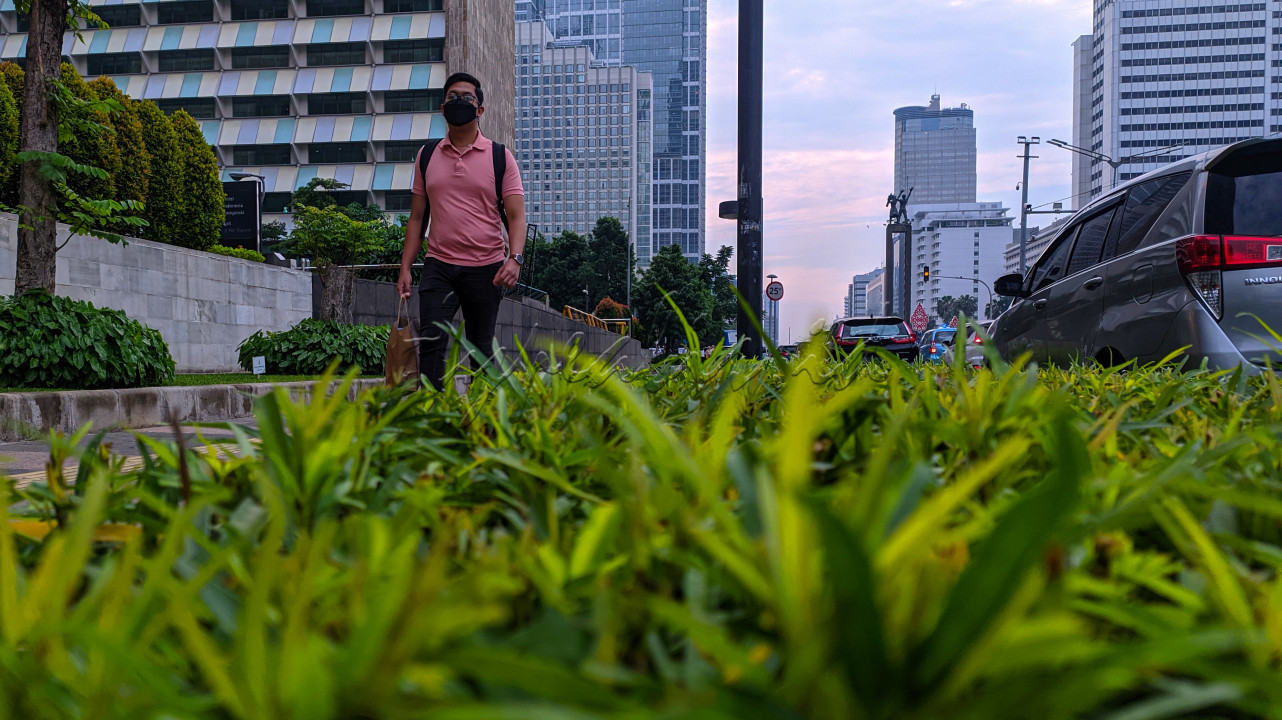 Seorang warga berjalan di kawasan Bundaran HI, Jakarta, Sabtu (28/5/2022). Kawasan Bundaran HI semakin di tata dan dipercantik dengan adanya hiasan tanaman di setiap sudutnya.