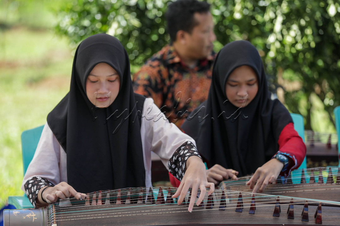 Mempunyai bentuk seperti kotak yang cembung, Guzheng terbuat dari kayu sebagai kotak suara, di atasnya terbentang 21 senar. 