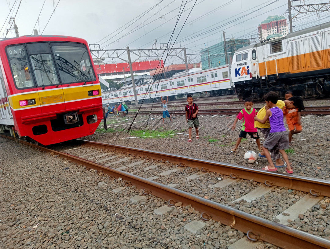 Sekelompok anak kecil nekat bermain di rel kereta, kurangnya lahan terbuka hijau memaksa mereka bermain di tempat yang berbahaya bagi nyawa mereka.