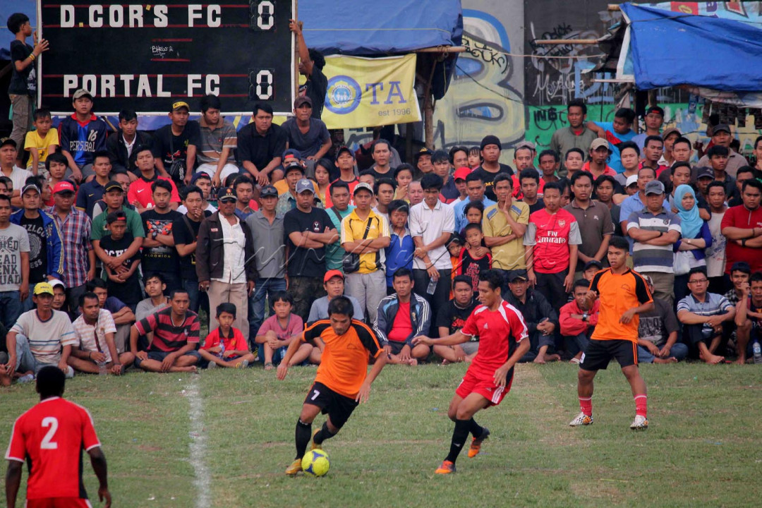 Tidak jauh dari lokasi parkir di pinggir jalan ternyata terdapat sebuah lapangan sepakbola yang dikelilingi oleh padatnya rumah penduduk akan melangsungkan sebuah Laga Final Sepak Bola.<br />
<br />
“ Ayo bro masuk buruan, nanti kita ga kebagian tempat ” percakapan tersebut lambat laun menghilang seiring langkah yang terus menjauh memasuki lapangan..<br />
