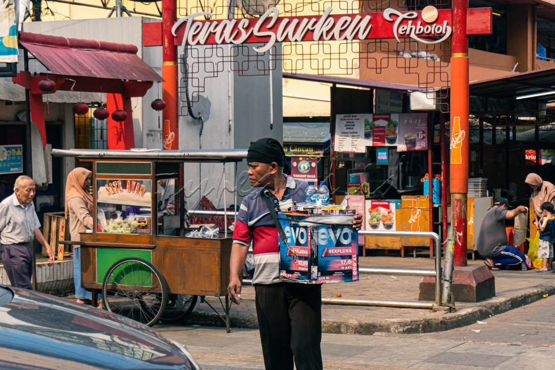 Seorang pedagang asongan yang tengah berkeliling mencari pembeli di sekitar pasar di Kota Bogor.