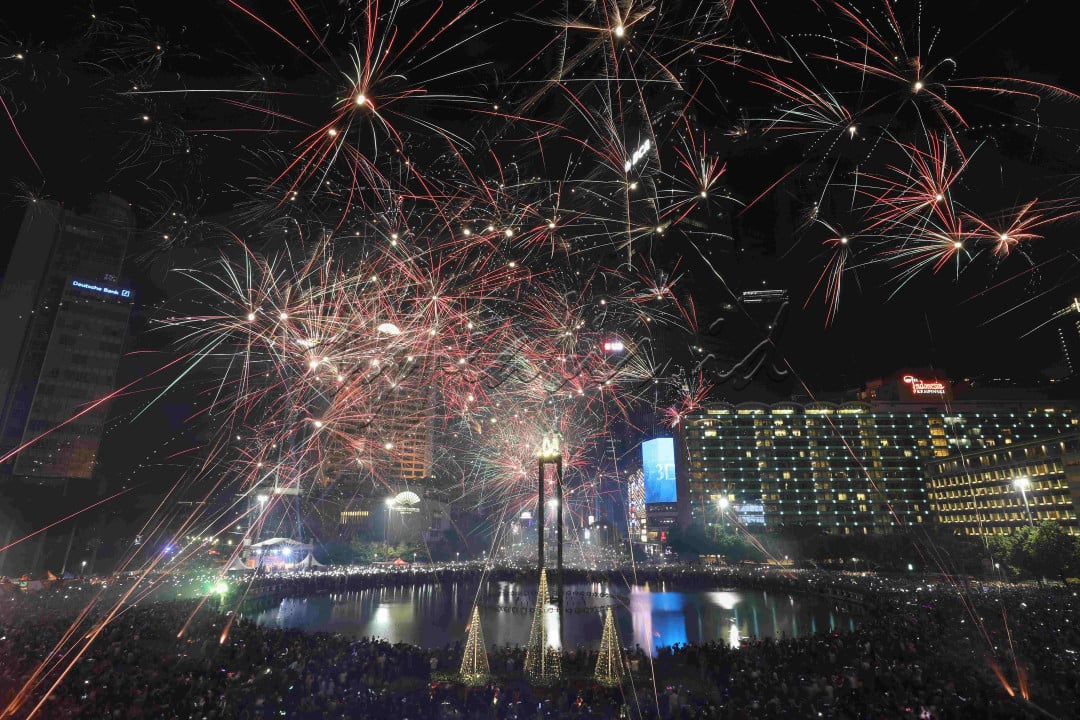 Kembang api menghiasi langit kawasan Bundaran Hotel Indonesia (HI), Jakarta, saat malam pergantian tahun baru 2023 di Jakarta, Minggu (1/1/2023).