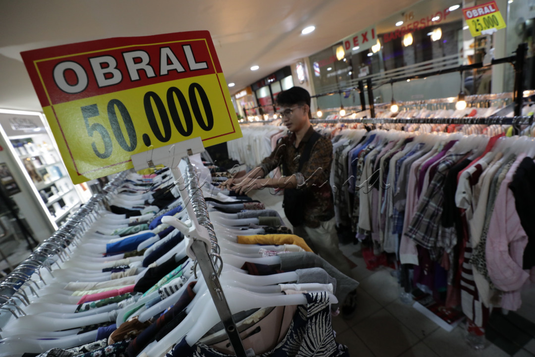 Pengunjung memilih baju bekas import di Jakarta. Dewasa ini tren fashion baju bekas import atau yang lebih dikenal dengan thrifting sedang populer di kalangan anak muda.