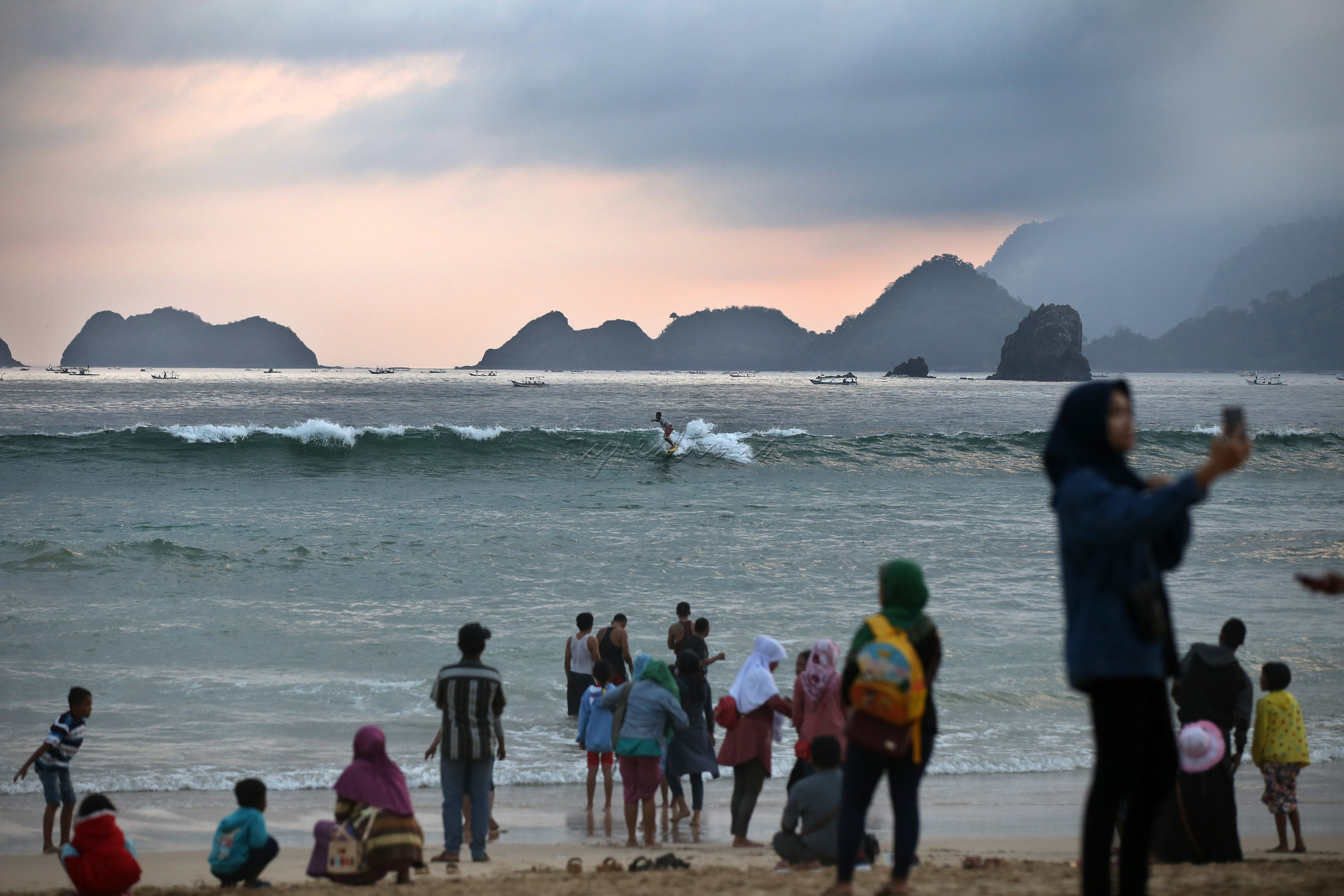 Sejumlah wisatawan menikmati sunset di kawasan pantai Merah di Banyuwangi, Jawa Timur. Pantai merah merupakan salah satu daya tarik pariwisata di Jawa Timur.