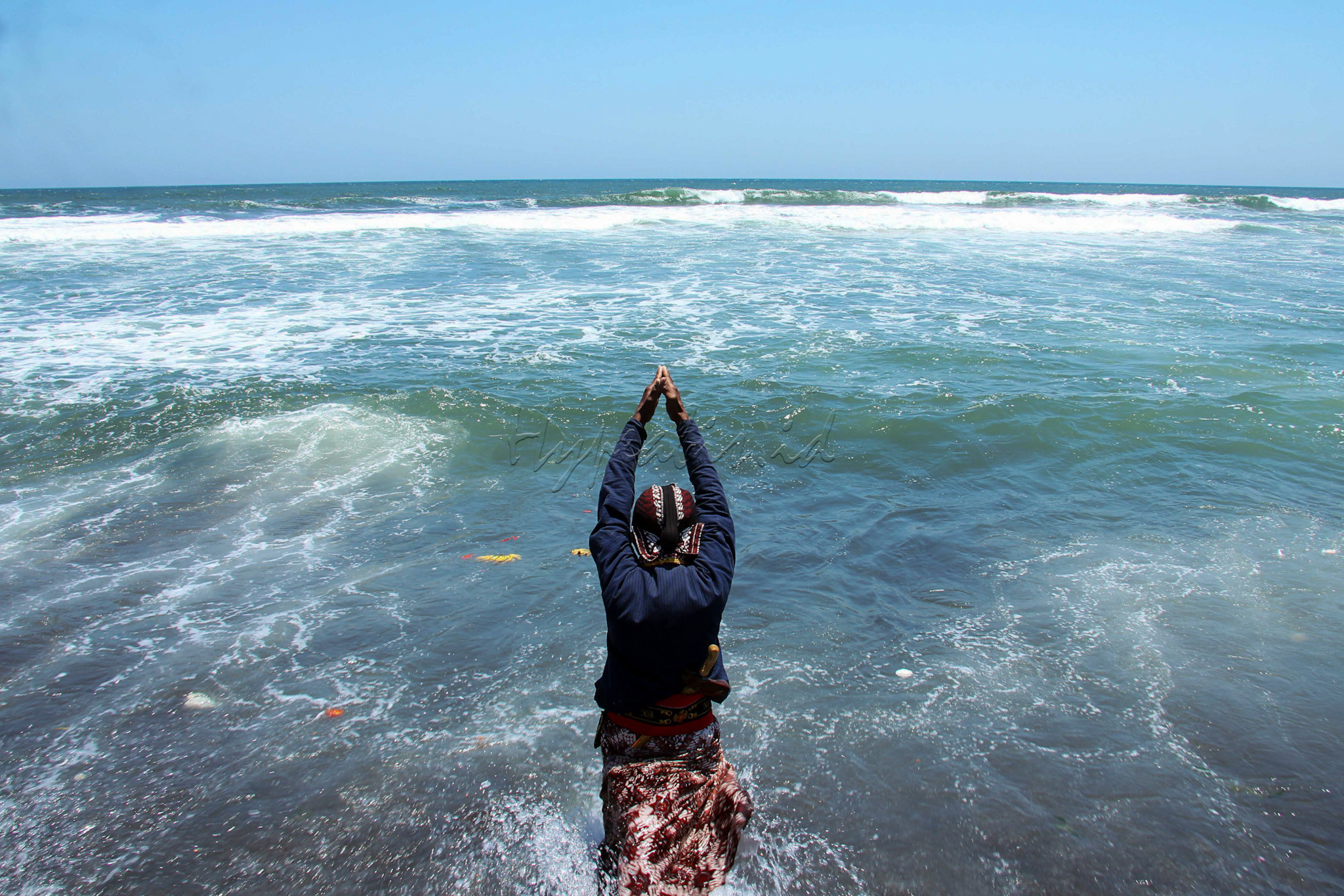 Abdi dalem melakukan doa saat ritual larung sesaji memperingati 1 Suro di Pantai Goa Cemara, Bantul, Yogyakarta.